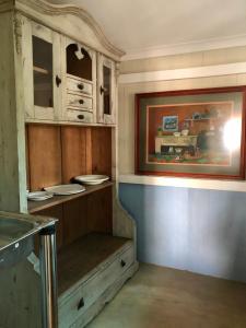a kitchen with wooden cabinets and plates on a shelf at Houghton Rosebank Cottage with deck overlooking pool in Johannesburg