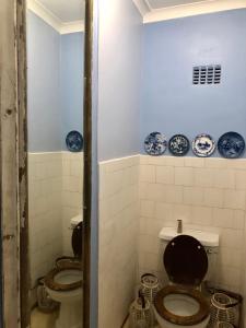 dois WC numa casa de banho com placas azuis na parede em Houghton Rosebank Cottage with deck overlooking pool em Joanesburgo