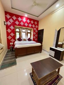 1 dormitorio con cama y pared roja en Hotel Golden Night Jaisalmer, en Jaisalmer