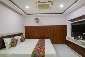 a bedroom with a bed and a tv on the wall at FabHotel Leaf Paradise in Lucknow