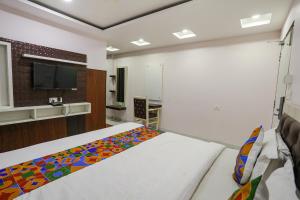 - une chambre avec un lit et une télévision murale dans l'établissement FabHotel Leaf Paradise, à Lucknow