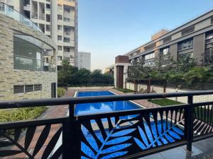 - un balcon avec une piscine et des bâtiments dans l'établissement Little nest Homestay, à Pune