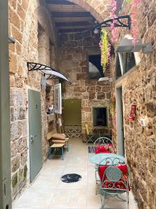 a patio with a table and chairs in a stone building at Hebi house in ‘Akko