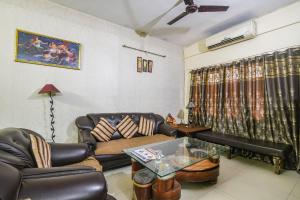 a living room with a couch and a table at FabHotel Maadhavam Residence in Patna