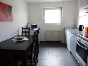 a kitchen with a black table and a table and chairs at Ferienwohnungen Yvonne Sigg in Rust