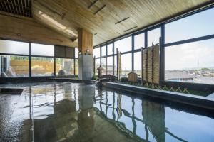 ein großes Schwimmbecken in einem Gebäude mit Fenstern in der Unterkunft Hotel Ryutouen in Saga