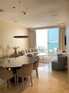 uma sala de estar com uma mesa e cadeiras e um sofá em FIVE Palm Resort - Luxury 2BR - Sea View em Dubai