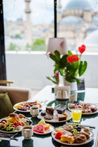 a table with plates of breakfast food on it at Mest Hotel Istanbul Sirkeci in Istanbul