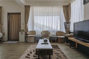 a living room with a flat screen tv and a couch at Mountain Traveler Inn in Jiufen