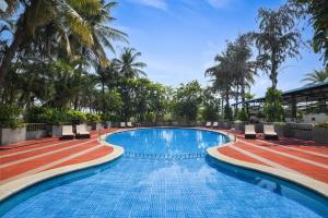 a large swimming pool with palm trees in the background at Fortune Hosur - Member ITC's Hotel Group in Hosūr