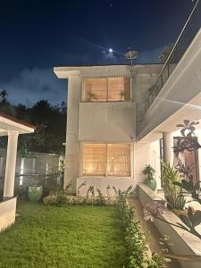 a white house with a lawn in front of it at Villa Ithaka by Youkoso in Chennai