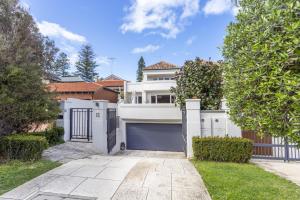 a white house with a gate and a driveway at Cottesloe Aqua Retreat - Executive Escapes in Perth
