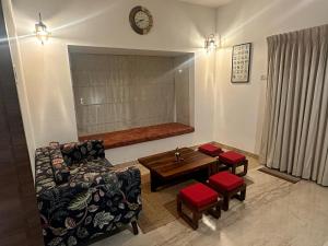 uma sala de estar com um sofá e uma mesa em Villa Ithaka by Youkoso em Chennai