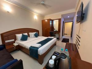 Blue Bliss Hotel By PPH Living في بانغالور: غرفه فندقيه سرير وتلفزيون