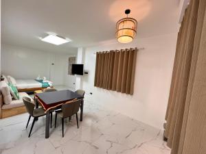 a dining room with a table and chairs and a bedroom at Lighthouse Inn Corporation former Lucky Tito Dmall Boracay in Boracay