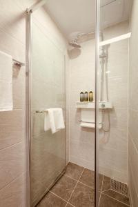 a shower with a glass door in a bathroom at Sollago Myeongdong Hotel & Residence in Seoul