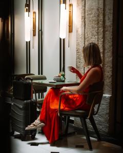 a woman in a red dress sitting at a table at Mest Hotel Istanbul Sirkeci in Istanbul