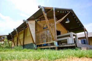 a house with a porch and a porch swing at Glamping Nieuw Heeten in Nieuw-Heeten