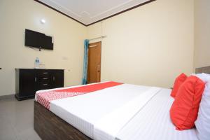 a bedroom with a bed and a flat screen tv at OYO Aggarwal Classic Paradise in Amritsar
