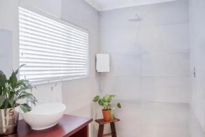 bagno con lavandino bianco e finestra di Staymore Guesthouse a Stellenbosch