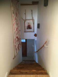 a hallway with stairs and a picture on the wall at Le clos du chêne - Chambres dans maison Bressane 