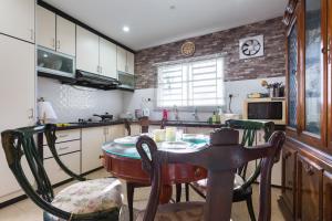 cocina con mesa y sillas en una habitación en Cosy HomeStay at Penang Island -Beach and Village, en Bayan Lepas
