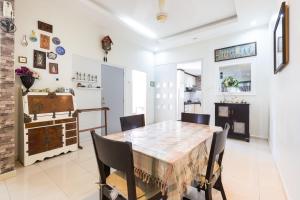 uma sala de jantar com mesa e cadeiras em Cosy HomeStay at Penang Island -Beach and Village em Bayan Lepas