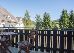 une table et des chaises en bois sur un balcon arboré dans l'établissement Ferienwohnung Alte Schule, à Winterberg