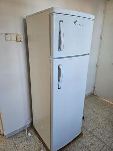a white refrigerator in a room next to a wall at App 2 chambres rdc 200m de la plage in Mezraya