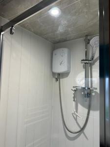 een douche in een wit betegelde badkamer met een douche bij F17 Rickardos Holiday Lets in Mablethorpe