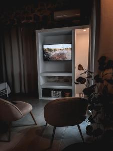 a living room with two chairs and a flat screen tv at Vigla Villas in Volímai