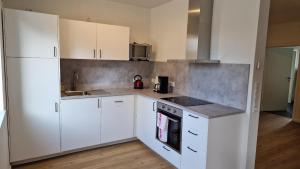 a kitchen with white cabinets and white appliances at Ferienwohnung Pütz in Saarburg