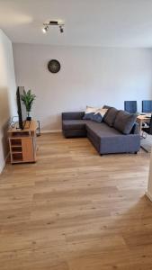 a living room with a couch and a wooden floor at Ferienwohnung Pütz in Saarburg