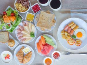 una mesa con platos de diferentes tipos de alimentos en Novotel Bangkok Sukhumvit 4 en Bangkok