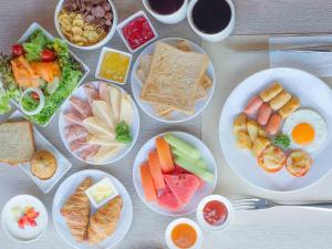 een tafel met borden van verschillende soorten levensmiddelen bij Novotel Bangkok Sukhumvit 4 in Bangkok