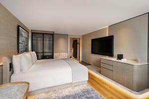 sypialnia z dużym łóżkiem i telewizorem z płaskim ekranem w obiekcie JW Marriott Auckland w Auckland
