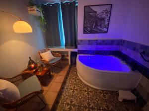 a bathroom with a large tub with purple lighting at Casa Campana in Arcos de la Frontera