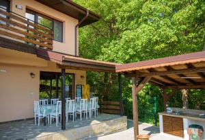 une terrasse avec une table et des chaises. dans l'établissement Вила Здравец, à Chipka