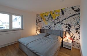 sypialnia z łóżkiem i ścianą z graffiti w obiekcie Casa Lorsch 1 w mieście Lorsch