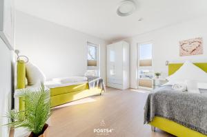 a bedroom with two beds and a potted plant at Ferienwohnung Küstenliebe Olpenitz in Olpenitz