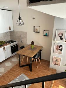 eine Küche und ein Esszimmer mit einem Holztisch in der Unterkunft Mia’s duplex apartment in Skopje
