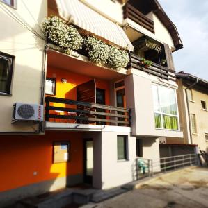 Edificio naranja y blanco con balcón en Theatre Apartments, en Bitola