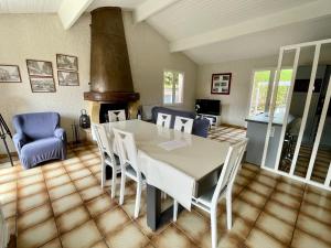 a dining room with a white table and chairs at Holiday house with garden and terrace close to the ocean in Lacanau-Ocean in Lacanau