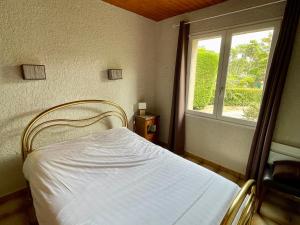 a bedroom with a white bed with a window at Holiday house with garden and terrace close to the ocean in Lacanau-Ocean in Lacanau