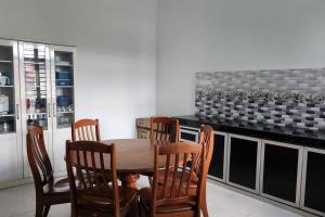 a kitchen with a wooden table and four chairs at Astaka Homestay Kok Lanas in Ketereh