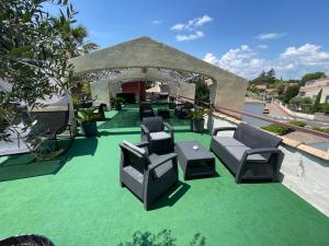 a patio with chairs and tables on a green lawn at Hôtel Ulysse Montpellier Centre in Montpellier