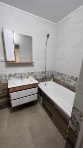 a bathroom with a tub and a sink and a mirror at ЖК Ауэзова1 in Kokshetau
