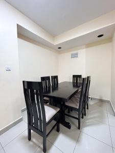 a dining room with a black table and chairs at Karibu house in Dar es Salaam