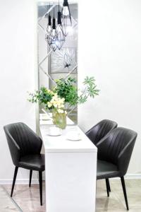 a dining room table with two chairs and a vase of flowers at HB apartments Mitskevichi in Tbilisi City