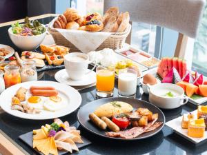 a breakfast table with breakfast foods and drinks at Mercure Bangkok Sukhumvit 24 in Bangkok